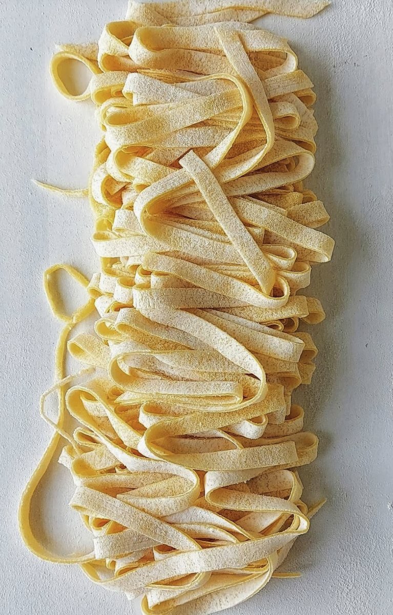 Fresh floured tagliatelle laid out on the worktop